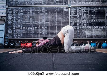 Young woman stretching upper body in gym View Large Photo Image Stock Image - Young woman stretching upper body in gym. Fotosearch