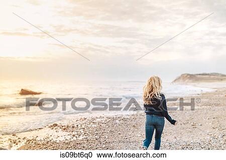 Young woman strolling along beach, rear view, Menemsha, Martha's Vineyard, Massachusetts, USA View Large Photo Image Stock Image - Young woman strolling along beach, rear view, Menemsha, Martha's Vineyard, Massachusetts, USA. Fotosearch