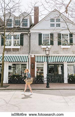 Young woman strolling along street carrying straw bag, Menemsha, Martha's Vineyard, Massachusetts, USA View Large Photo Image Stock Image - Young woman strolling along street carrying straw bag, Menemsha, Martha's Vineyard, Massachusetts, USA. Fotosearch