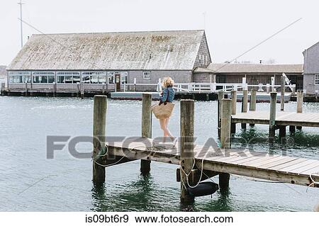 Young woman strolling on wooden pier, Menemsha, Martha's Vineyard, Massachusetts, USA View Large Photo Image Stock Photo - Young woman strolling on wooden pier, Menemsha, Martha's Vineyard, Massachusetts, USA. Fotosearch
