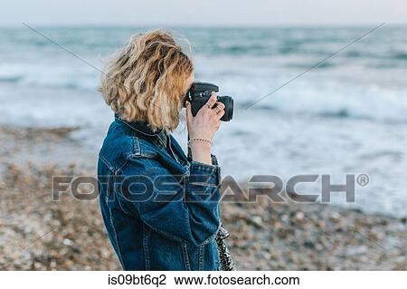 Young woman taking photographs from beach, Menemsha, Martha's Vineyard, Massachusetts, USA View Large Photo Image Stock Image - Young woman taking photographs from beach, Menemsha, Martha's Vineyard, Massachusetts, USA. Fotosearch