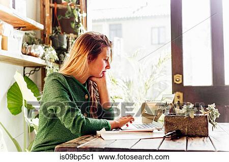 Young woman using laptop in cafe View Large Photo Image Stock Image - Young woman using laptop in cafe. Fotosearch