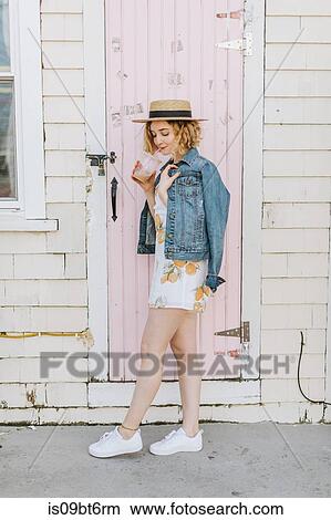 Picture - Young woman wearing boater drinking iced coffee, Menemsha, Martha's Vineyard, Massachusetts, USA. Fotosearch