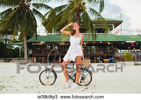 Young woman with bicycle looking away on sandy beach, Krabi, Thailand View Large Photo Image Stock Image - Young woman with bicycle looking away on sandy beach, Krabi, Thailand. Fotosearch