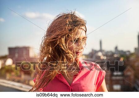 Young woman with long windswept hair at roof party in London, UK View Large Photo Image Stock Photography - Young woman with long windswept hair at roof party in London, UK. Fotosearch