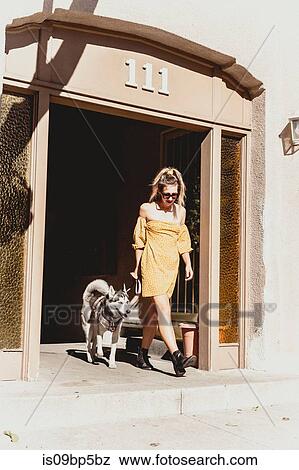 Young woman with pet dog at entrance of building View Large Photo Image Stock Photo - Young woman with pet dog at entrance of building. Fotosearch