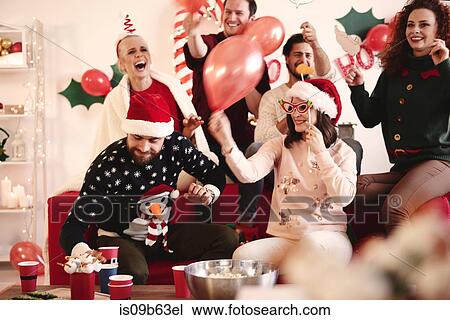 Young women and men having fun laughing at christmas party View Large Photo Image Stock Image - Young women and men having fun laughing at christmas party. Fotosearch