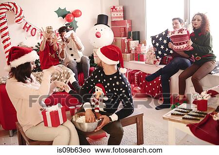 Young women and men throwing popcorn at christmas party View Large Photo Image Picture - Young women and men throwing popcorn at christmas party. Fotosearch