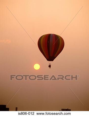 Stock Image - Colourful hot-air balloon with sun in the background. Fotosearch