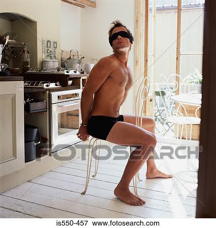 Stock Photo - Blindfolded man sitting on chair. Fotosearch