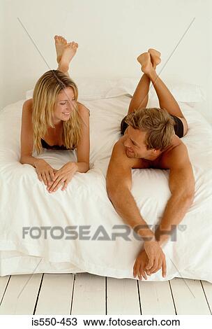 Stock Image - Couple on bed talking. Fotosearch