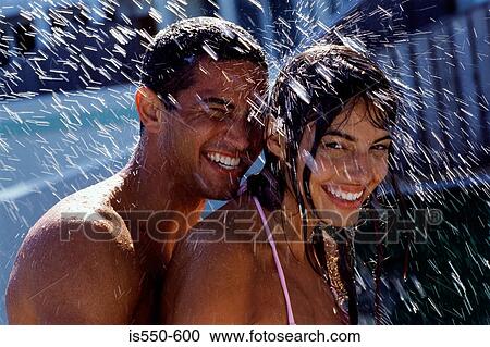 Stock Image - Couple playing with water in garden. Fotosearch