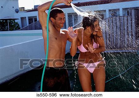 Couple playing with water in garden View Large Photo Image Stock Photograph - Couple playing with water in garden. Fotosearch