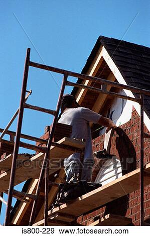 Stock Photo - Builder working on house. Fotosearch