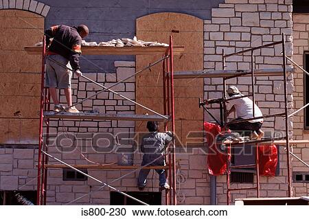 Stock Image - Builders working on house. Fotosearch