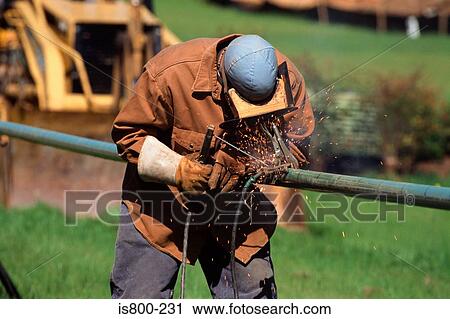 Stock Image - Construction worker welding a pipe. Fotosearch