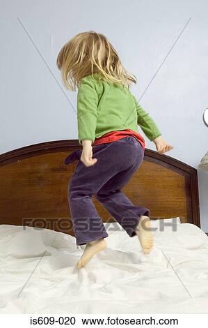 Stock Image - Girl jumping on bed. Fotosearch