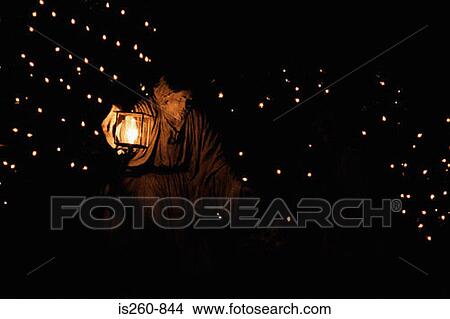 Statue of a man holding an illuminated lantern View Large Photo Image Picture - Statue of a man holding an illuminated lantern. Fotosearch