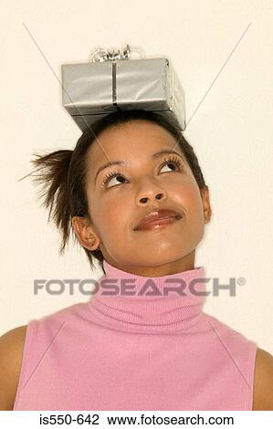 Stock Image - Woman balancing a gift on head. Fotosearch