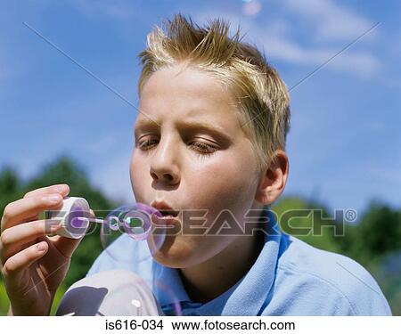 Picture - Boy blowing bubble in the sun.. Fotosearch