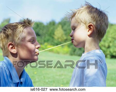 Brothers sharing a long sweet. View Large Photo Image Stock Photo - Brothers sharing a long sweet.. Fotosearch
