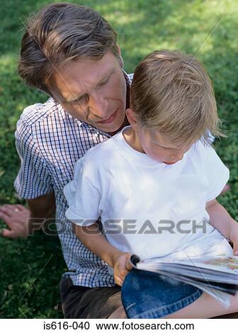 Father and son read outdoors. View Large Photo Image Stock Image - Father and son read outdoors.. Fotosearch