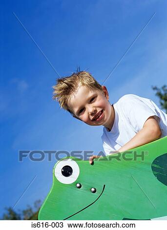 Happy boy riding wooden frog. View Large Photo Image Stock Image - Happy boy riding wooden frog.. Fotosearch