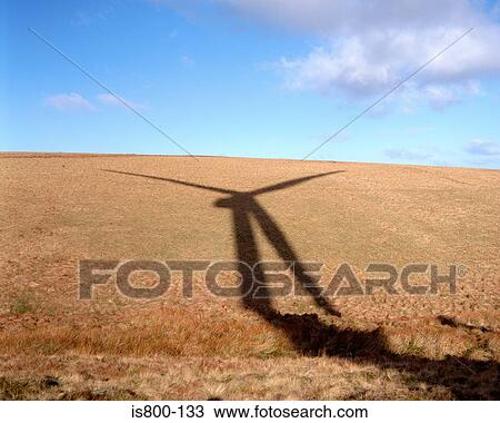 Stock Image - Wind turbine shadow on hill. Fotosearch
