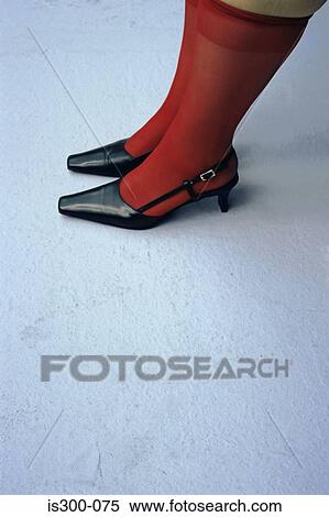 Stock Photography - Feet in red stockings and black shoes. Fotosearch