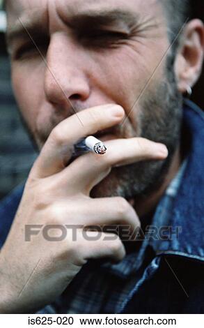 Man smoking a cigarette View Large Photo Image Stock Image - Man smoking a cigarette. Fotosearch