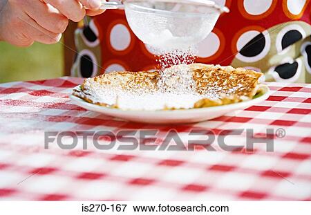Sieving sugar on a pancake View Large Photo Image Stock Photo - Sieving sugar on a pancake. Fotosearch