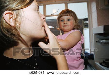Stock Image - Woman smoking near baby. Fotosearch