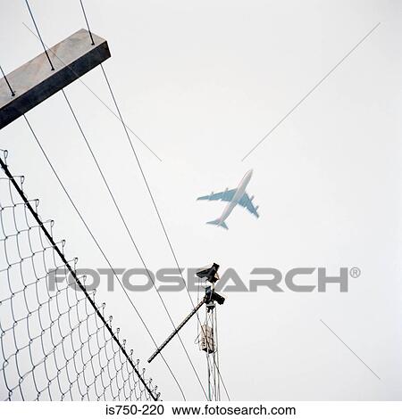 Aeroplane above wire fence View Large Photo Image Stock Image - Aeroplane above wire fence. Fotosearch