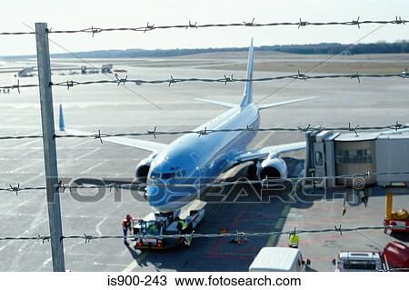 Stock Image - Aeroplane behind barbed wire fence. Fotosearch