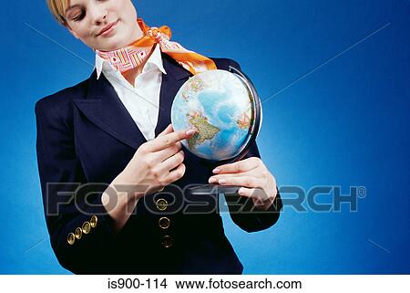 Picture - Air hostess pointing to a globe. Fotosearch