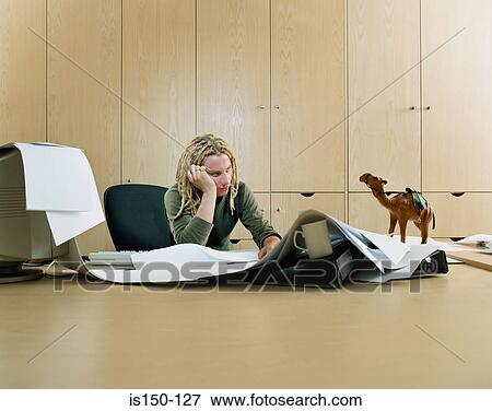 Stock Photo - Bored man at messy desk. Fotosearch