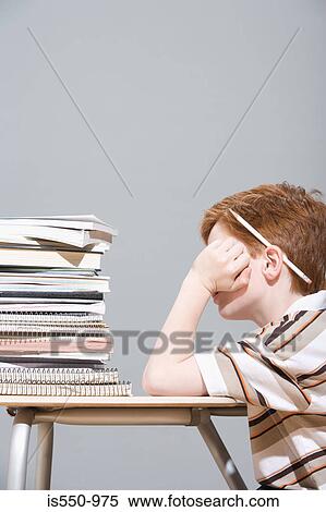 Boy with a pile of school books View Large Photo Image Stock Photography - Boy with a pile of school books. Fotosearch