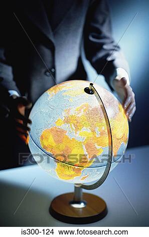 Businessman touching a globe View Large Photo Image Picture - Businessman touching a globe. Fotosearch