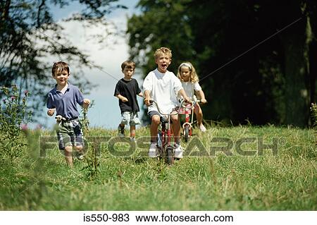 Children running and riding bikes View Large Photo Image Stock Image - Children running and riding bikes. Fotosearch