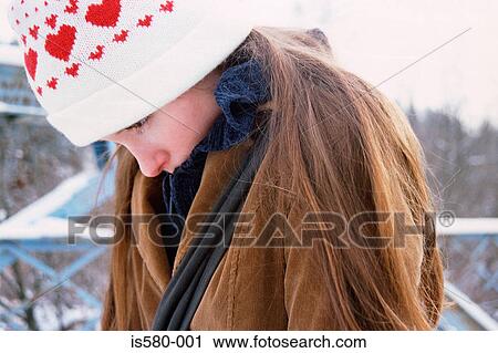 Stock Image - Girl hunching shoulders in cold. Fotosearch
