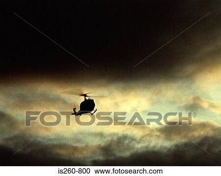 Helicopter in cloudy sky View Large Photo Image Stock Image - Helicopter in cloudy sky. Fotosearch