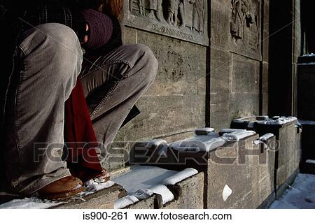Stock Image - Man sitting on carved wall. Fotosearch