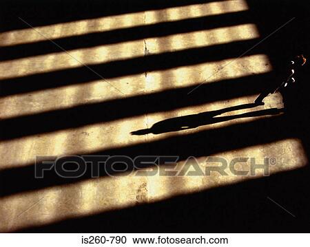 Person standing in shadows View Large Photo Image Stock Image - Person standing in shadows. Fotosearch