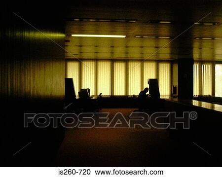 Stock Image - Silhouetted man in office. Fotosearch