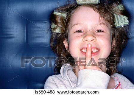 Smiling girl with finger on lips View Large Photo Image Stock Photo - Smiling girl with finger on lips. Fotosearch