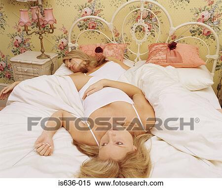 Two women lying in bed View Large Photo Image Stock Photography - Two women lying in bed. Fotosearch