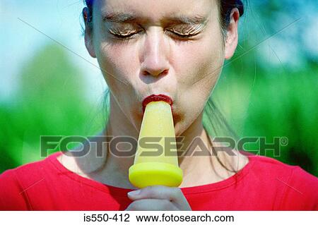 Stock Image - Woman eating an ice lolly. Fotosearch