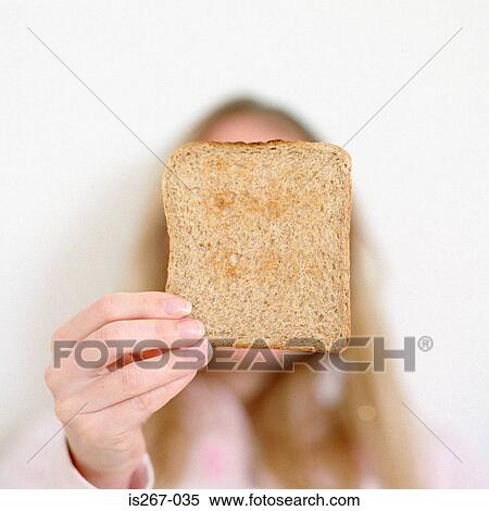Stock Photography - Woman holding slice of square toast. Fotosearch
