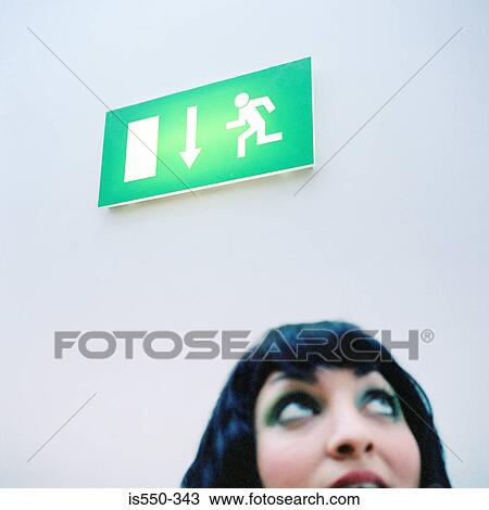 Woman looking toward exit sign View Large Photo Image Stock Image - Woman looking toward exit sign. Fotosearch