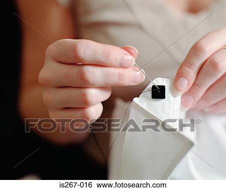 Woman sewing square button on shirt View Large Photo Image Stock Photograph - Woman sewing square button on shirt. Fotosearch